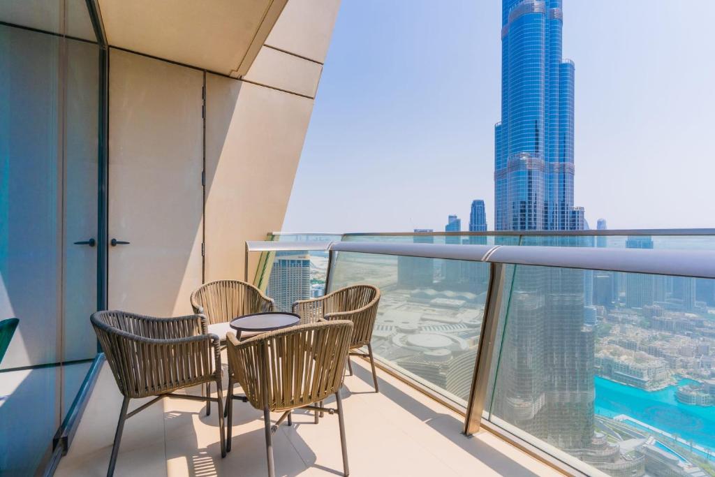 een balkon met stoelen en een tafel bovenop een gebouw bij LUXFolio Retreats - Amazing Full Burj Khalifa View in Dubai
