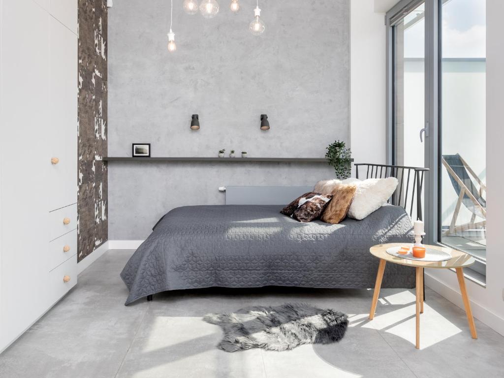 a bedroom with a bed and a table at Kraków Loft in Krakow