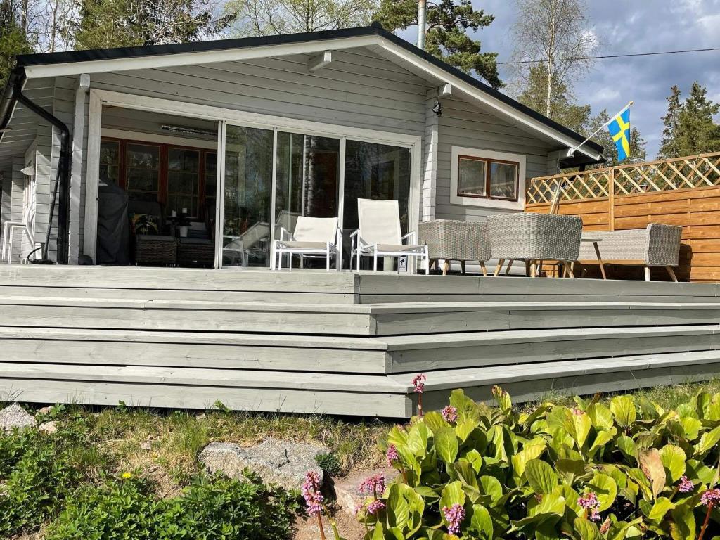 een huis met een veranda met stoelen en tafels bij Holiday home VäTö IV in Harg