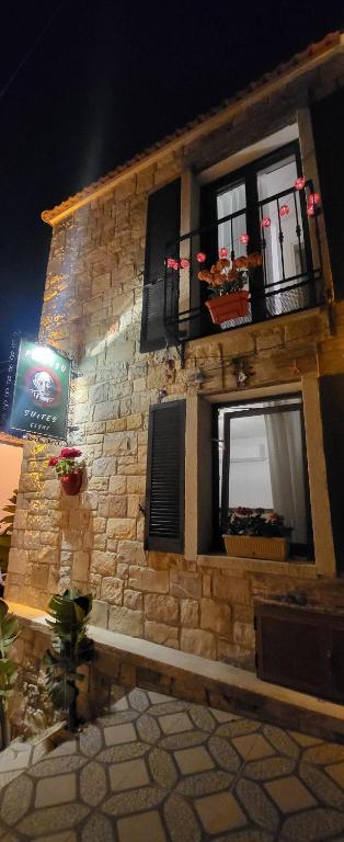 un edificio de ladrillo con ventanas y un cartel en él en Picasso Suites Çeşme, en Cesme