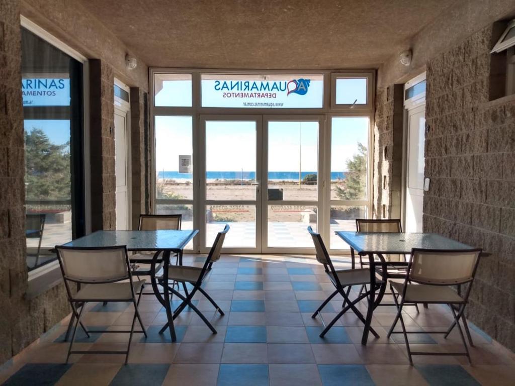 comedor con 2 mesas y sillas frente a una ventana en Aquamarinas Departamentos en Playas Doradas