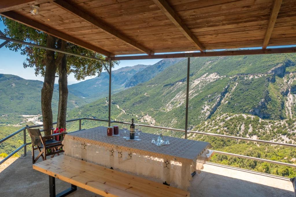 a table on a balcony with a view of mountains at Takis Apartments Tzoumerka 