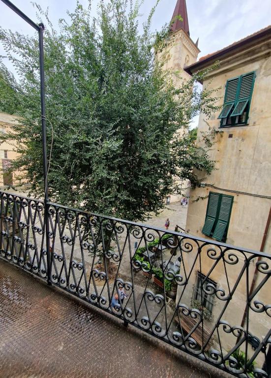 czarny płot przed budynkiem z drzewem w obiekcie Alla Mezzora - Finalborgo w mieście Finale Ligure