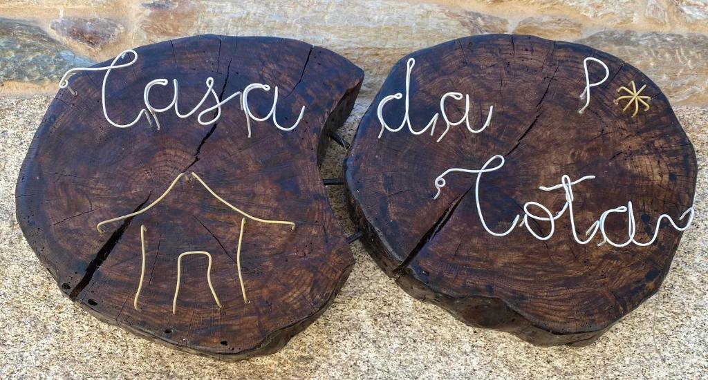 two logs with writing on them sitting on the ground at Casa da Cota in Monterroso