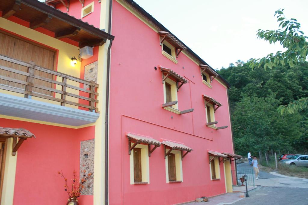 un edificio rojo con ventanas laterales en Agriturismo Pietro Falcone en Celico