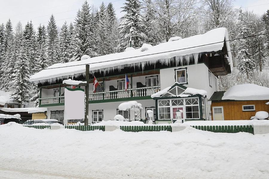 una grande casa con la neve sul tetto di Alpenpension ad Altaussee