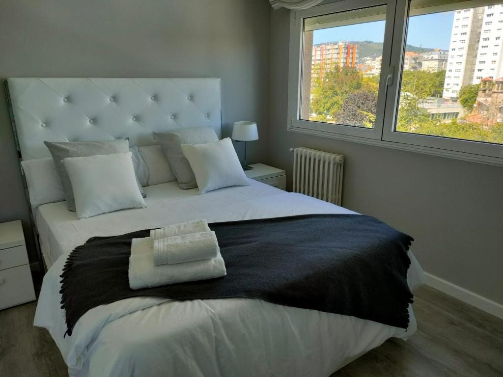 1 dormitorio con 1 cama blanca grande y ventana grande en Claro de Luna, en Pontevedra