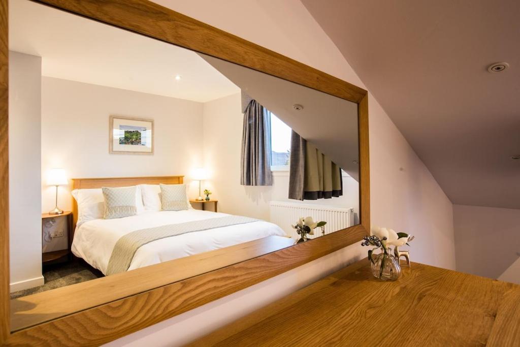 1 dormitorio con cama y espejo grande en Foinaven House, en Ullapool