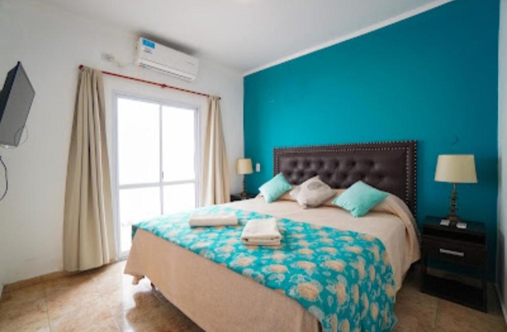 a blue bedroom with a bed with towels on it at Apartamento Lo de Ana in Termas de Río Hondo