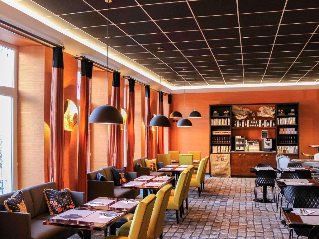 - un restaurant avec des tables et des chaises dans une salle dans l'établissement Mercure Strasbourg Centre Gare, à Strasbourg