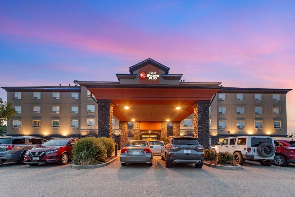 un estacionamiento con coches estacionados frente a un hotel en Best Western Plus The Inn at St Albert en St. Albert