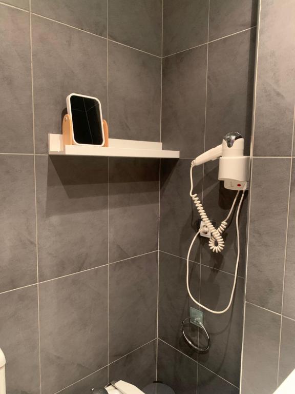 a bathroom with a shower with a phone on a shelf at NORDIC LAIA 4B - Soldeu - Bordes d'Envalira in Bordes d´Envalira