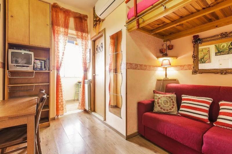 ein Wohnzimmer mit einem roten Sofa und einem Fenster in der Unterkunft CASA Bella in Rom