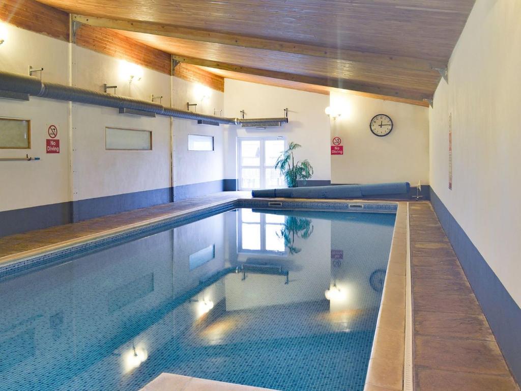 a swimming pool in a building with a indoor pool at Rook in Broadhempston