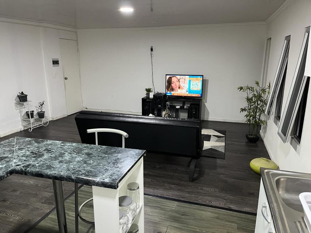 ein Wohnzimmer mit einem Klavier und einem TV in der Unterkunft Departamento en segundo piso de casa familiar in Iquique