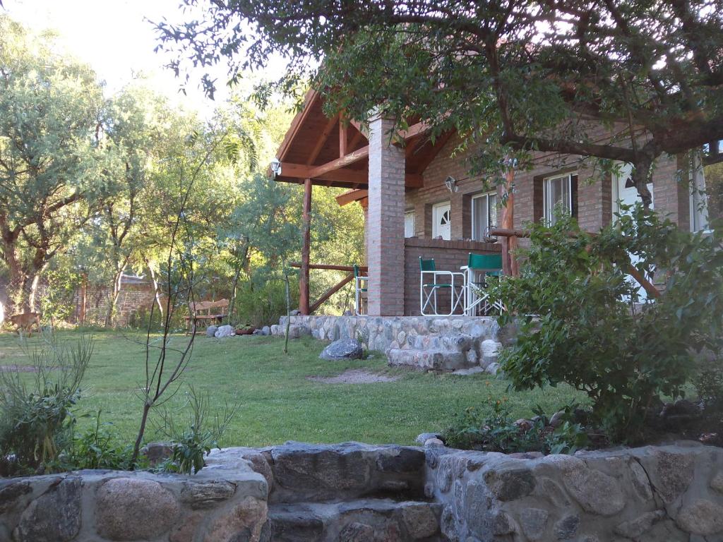 uma casa com uma parede de pedra em frente em Wilka Pacha - Casas Serranas em Capilla del Monte