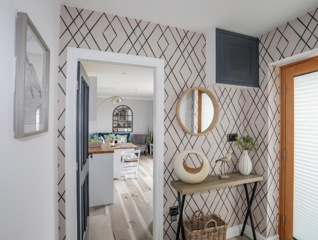 a kitchen and living room with a mirror on the wall at Trem Y Borth Apartment in Abersoch