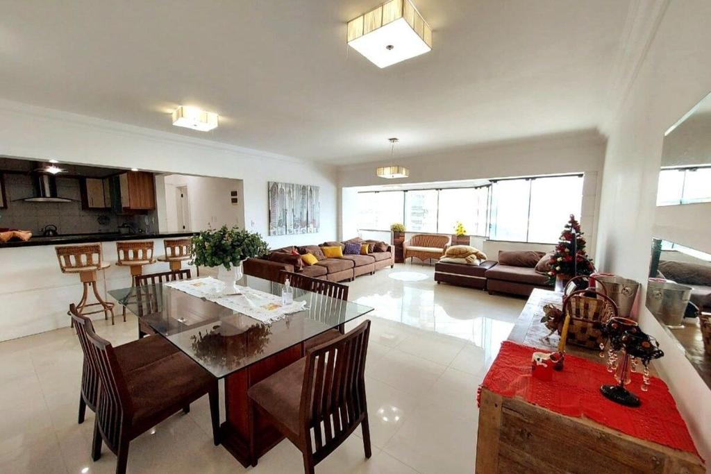 a large living room with a table and a kitchen at Apto Amplo 1SUI+2Q Quadra Mar 50m da Praia in Balneário Camboriú