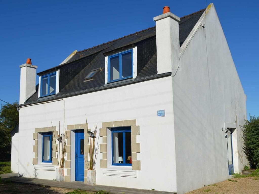 a white house with blue doors and a black roof at Holiday Home in Brittany near Sandy Beaches in Locquirec