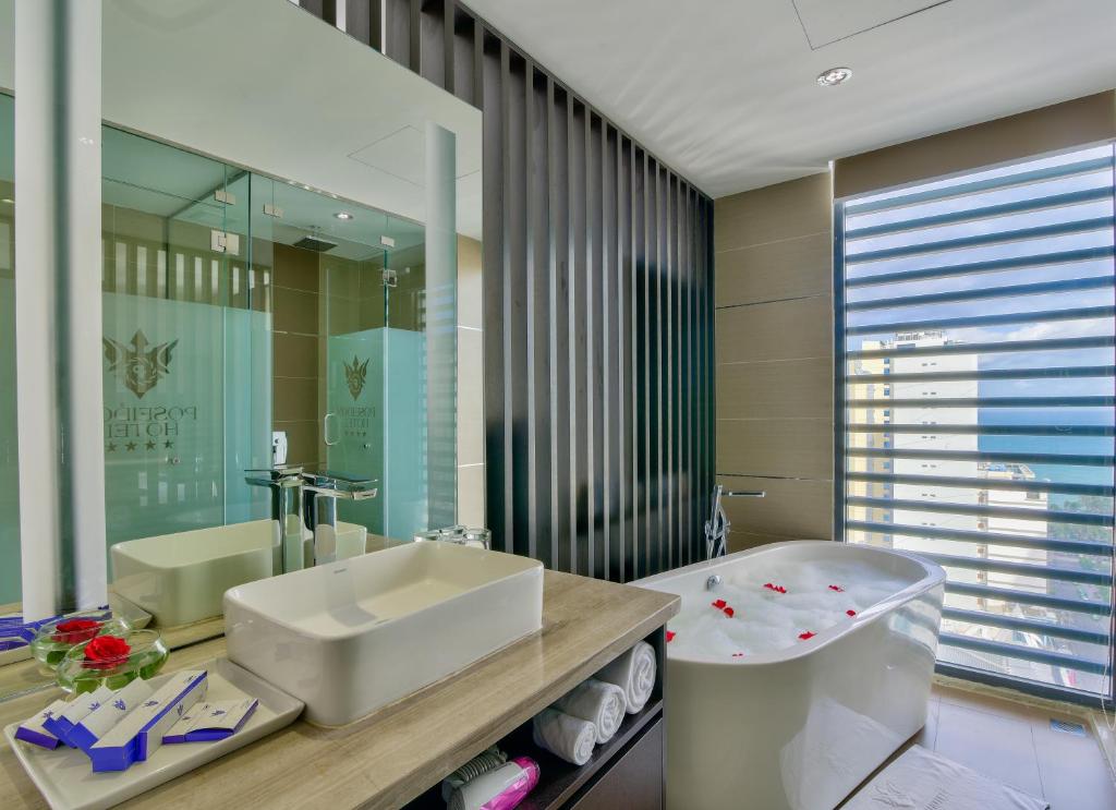 uma casa de banho com um lavatório, um WC e uma banheira em Poseidon Nha Trang em Nha Trang