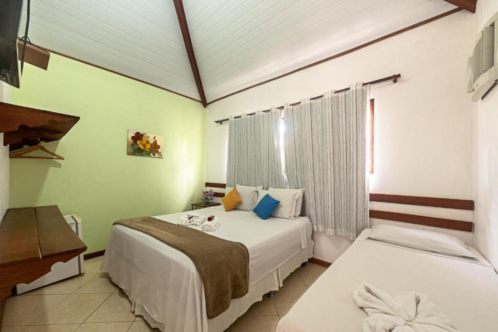 1 dormitorio con 2 camas y ventana en Pousada Sol e Mar, en Paraty