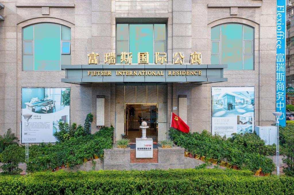 a building with a flag in front of it at Fietser International Residence in Shenzhen