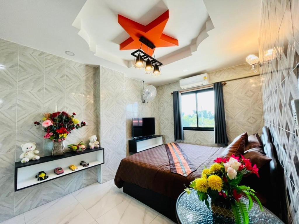 a bedroom with a bed and a star on the ceiling at โรงแรมเรือนคุณเล็ก กานต์สินี in Ban Tha Pho