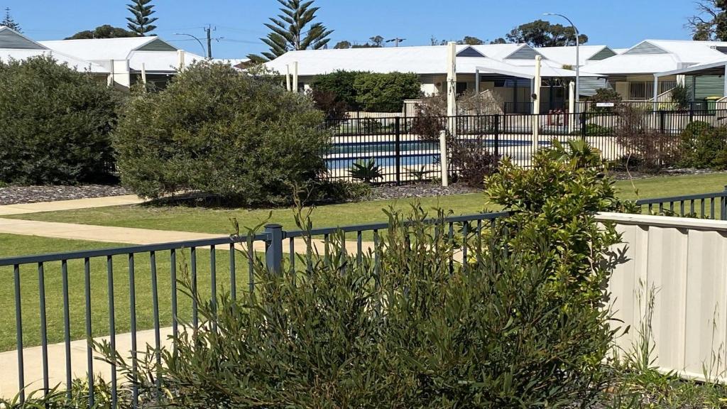 a fence in front of a house with a pool at Unit 24 Seafront Estate in Jurien Bay
