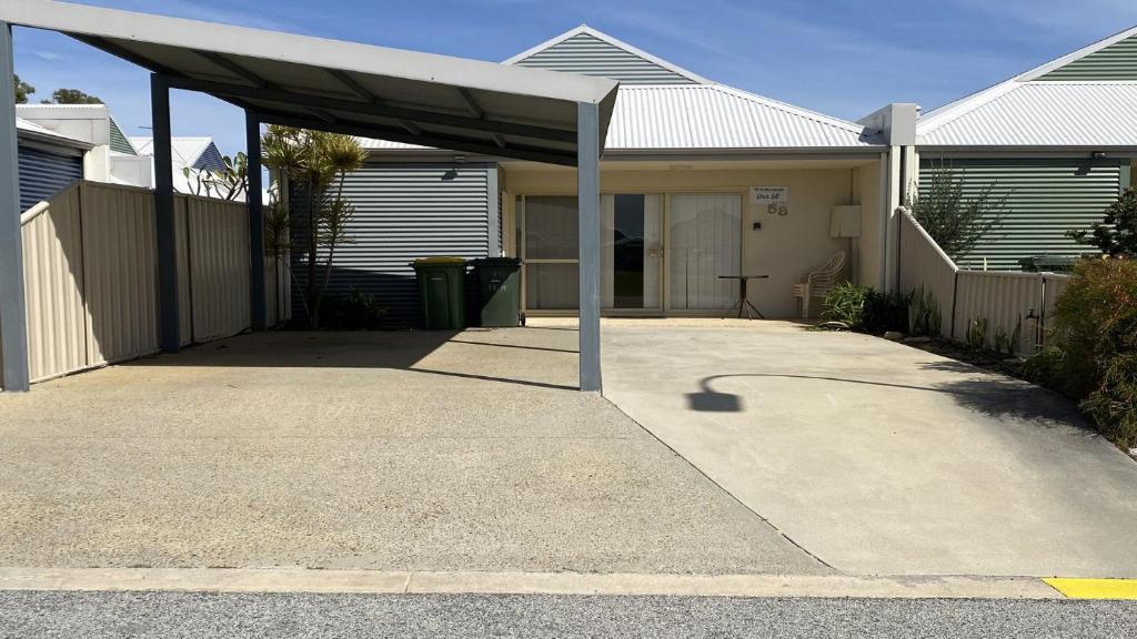 une maison avec un auvent au-dessus d'une allée dans l'établissement Unit 58 Seafront Estate, à Jurien Bay