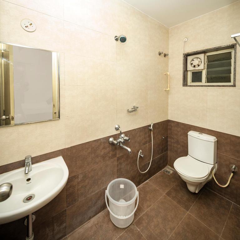a bathroom with a sink and a toilet and a mirror at HOTEL BALINOVA in Bangalore