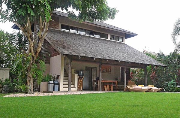 una casa con un gran edificio con un patio de césped en Duke's Bingin Villas, en Uluwatu