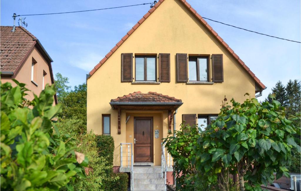 uma casa amarela com uma porta castanha e janelas em Gorgeous Home In Marmoutier With Kitchen em Marmoutier