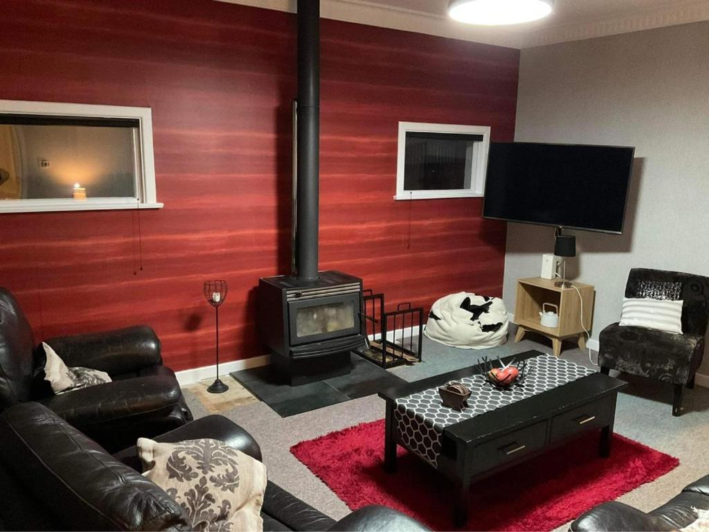 uma sala de estar com um fogão a lenha num quarto em Bungalow on Centre em Invercargill