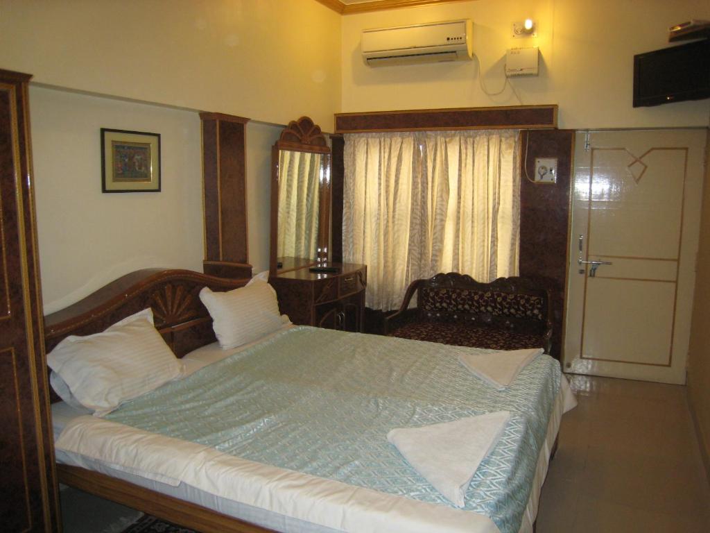 sypialnia z dużym łóżkiem i oknem w obiekcie Kedareswar B&B w mieście Waranasi