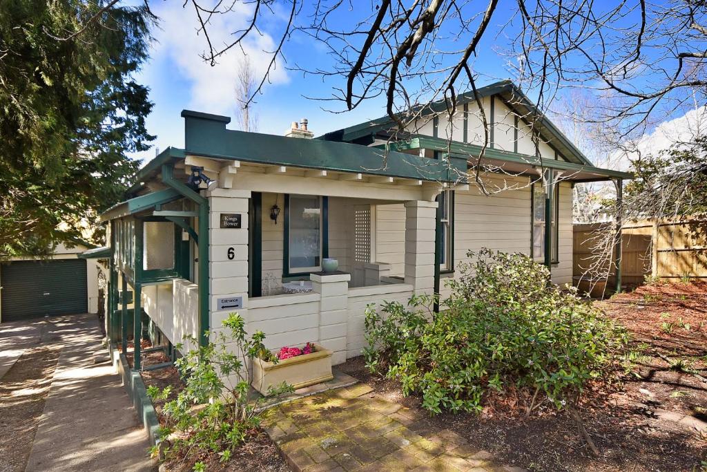 uma pequena casa branca com um telhado verde em Kings Bower em Katoomba