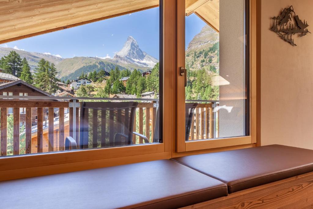 a room with a window with a view of a mountain at Hotel Jägerhof in Zermatt