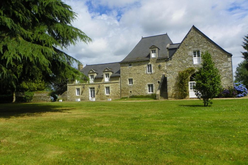 een oud stenen huis op een grasveld bij Manoir de Saint-Fiacre in Malansac