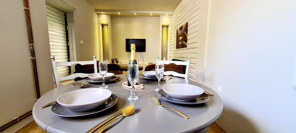 a dining room table with plates and glasses on it at Apartman 993 in Pale