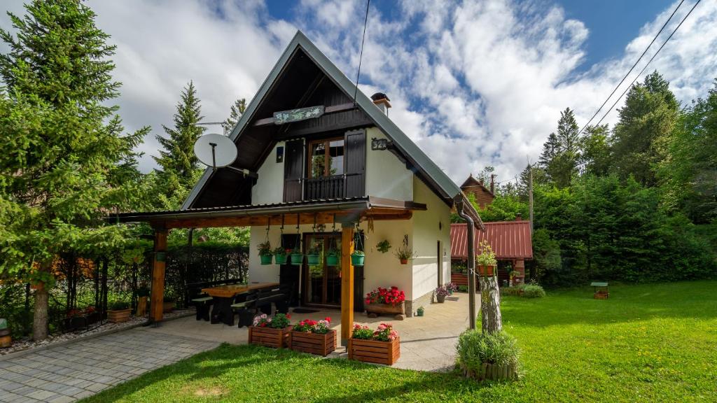 uma pequena casa com um telhado preto em Chalet House Olga em Crni Lug