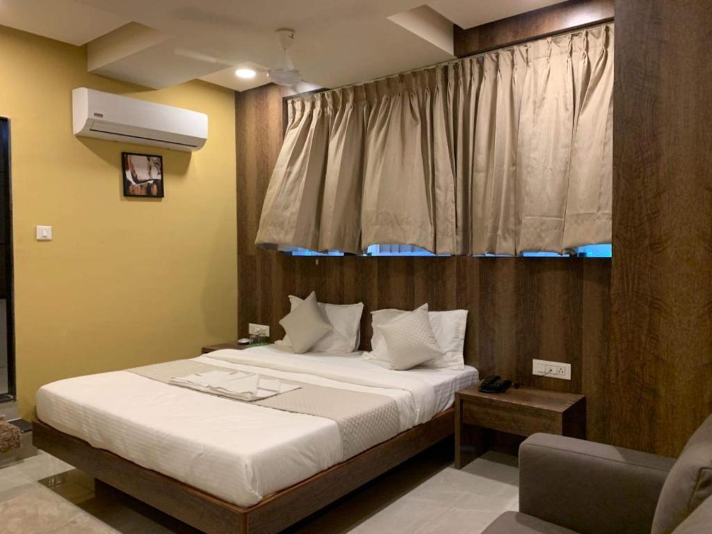 Hotel Radha krishna في أناند: غرفة نوم بسرير كبير ونافذة