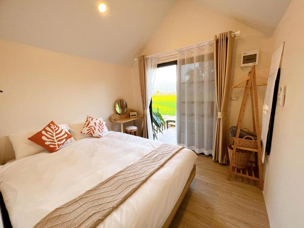 1 dormitorio con cama y ventana grande en Pua Na Nan Camping ปัวนาน่านแคมป์ปิ้ง, en Pua
