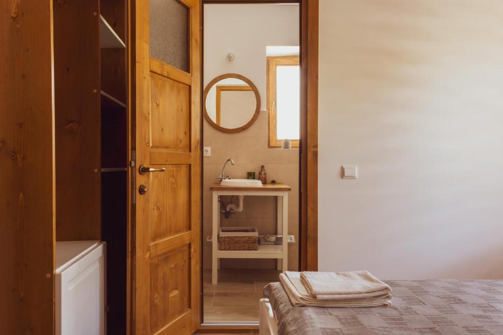 La salle de bains est pourvue d'un lit, d'un miroir et d'un lavabo. dans l'établissement Pensiunea Violin Panzió, à Băile Tuşnad