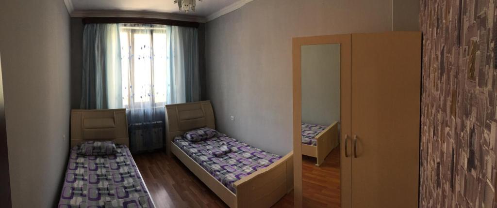 a small room with two beds and a mirror at Arm Hostel in Yerevan