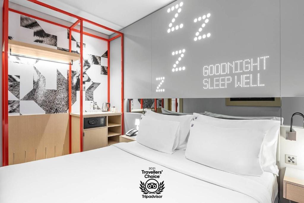 Studio M Arabian Plaza Hotel & Hotel Apartments في دبي: غرفة نوم بسرير كبير ومخدات بيضاء