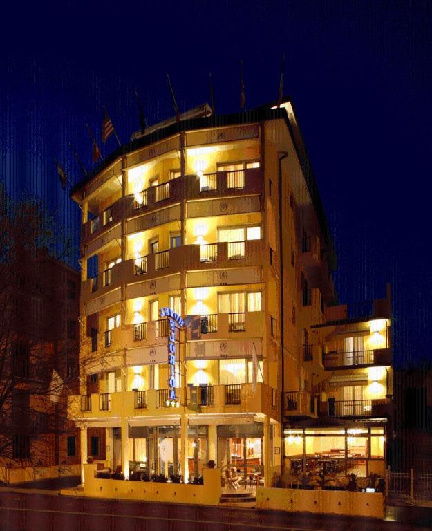a large building with a blue cross in front of it at Hotel Florida Lerici in Lerici