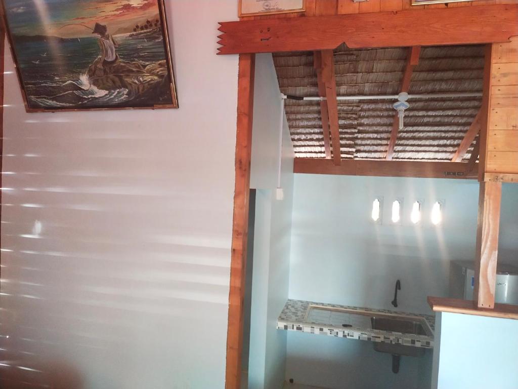 une cuisine avec des murs blancs et une peinture murale. dans l'établissement Homestay Pak Ucu, 