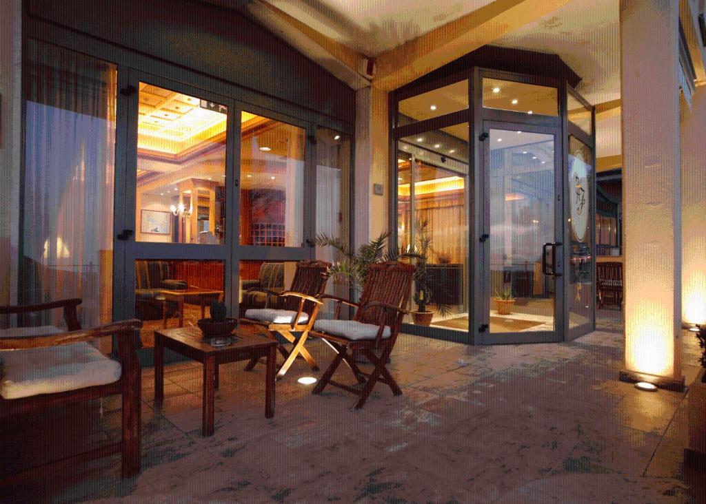 a lobby with chairs and a table and glass doors at Hotel Florida Lerici in Lerici