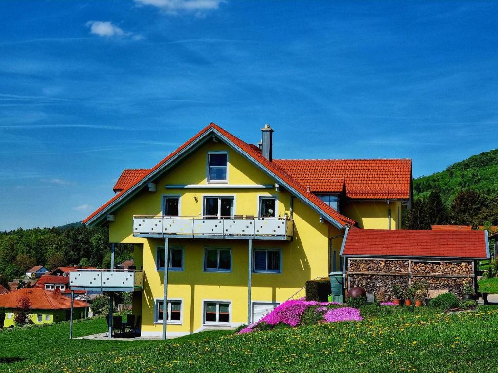 une grande maison jaune avec un toit rouge dans l'établissement Ferienhaus am Johannesbuhl, à Waldmünchen