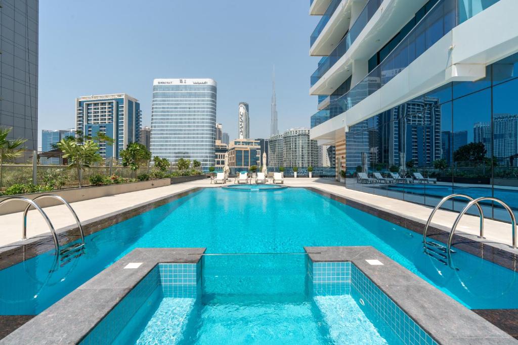a swimming pool with a city skyline in the background at Exclusive GLOBALSTAY Apartments in Business Bay Free Parking & More! in Dubai