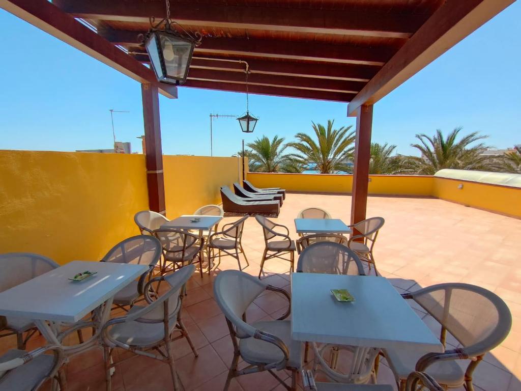 a group of tables and chairs on a patio at Puesta De Sol Residence in Lampedusa